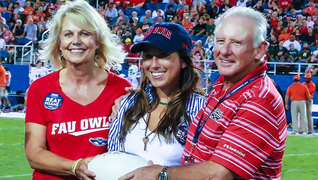 Schmidt family holds football on football field