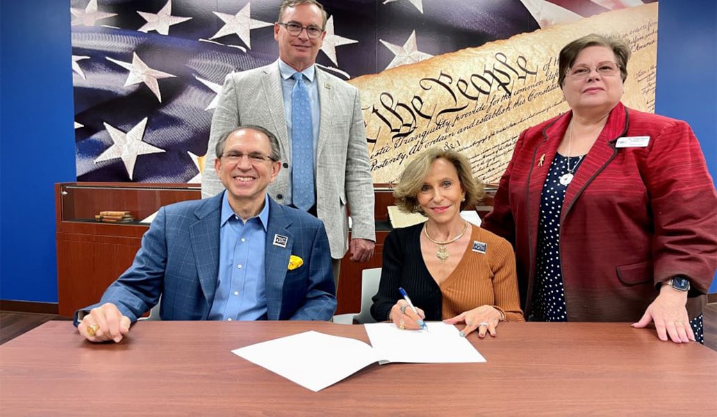 four people signing a paper