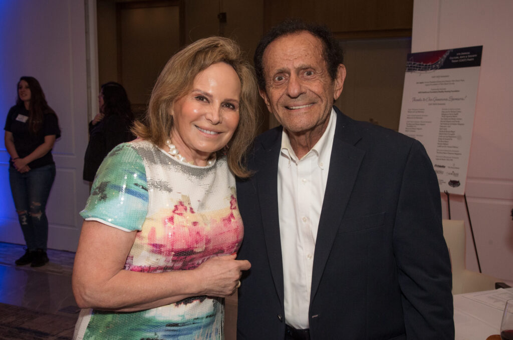 woman in dress smiles next to man in dark suit