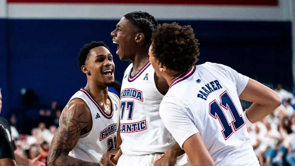 three basketball players celebrate on the court