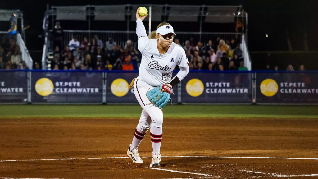 female softball player winds up for a pitch