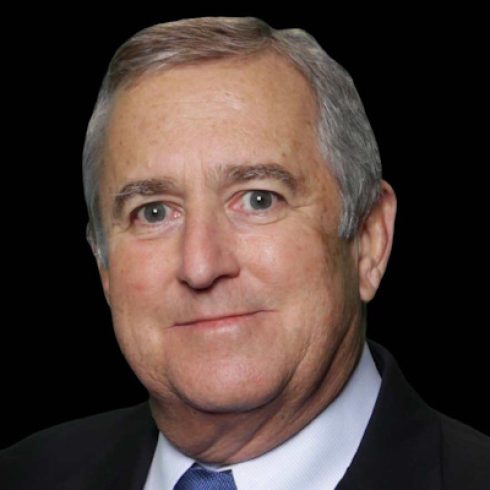 headshot of older man in suit with tie and a black background